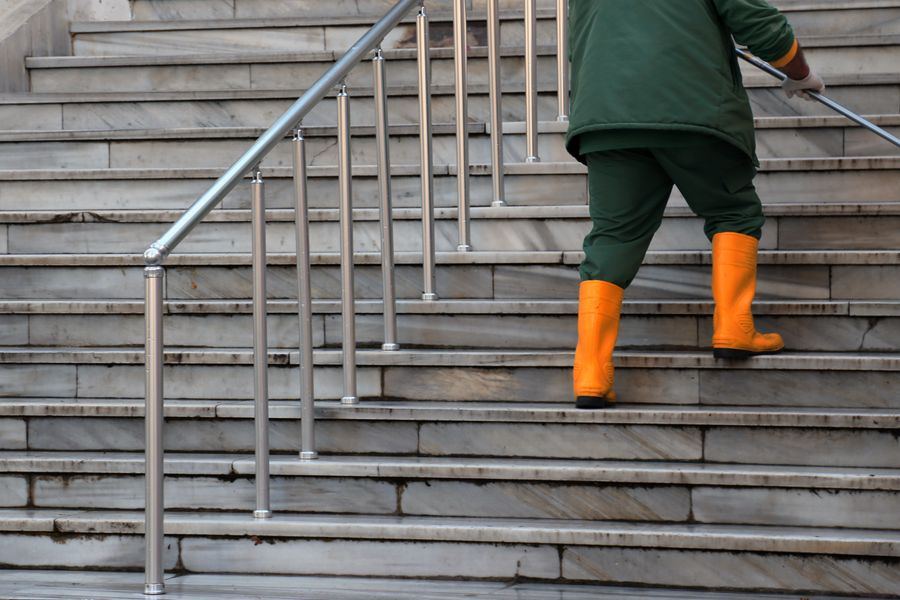 Reinigungskraft wischt eine Treppe