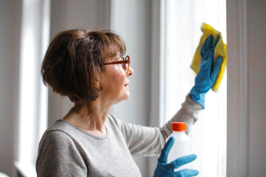 Fenster wird mit Sprühreiniger geputzt