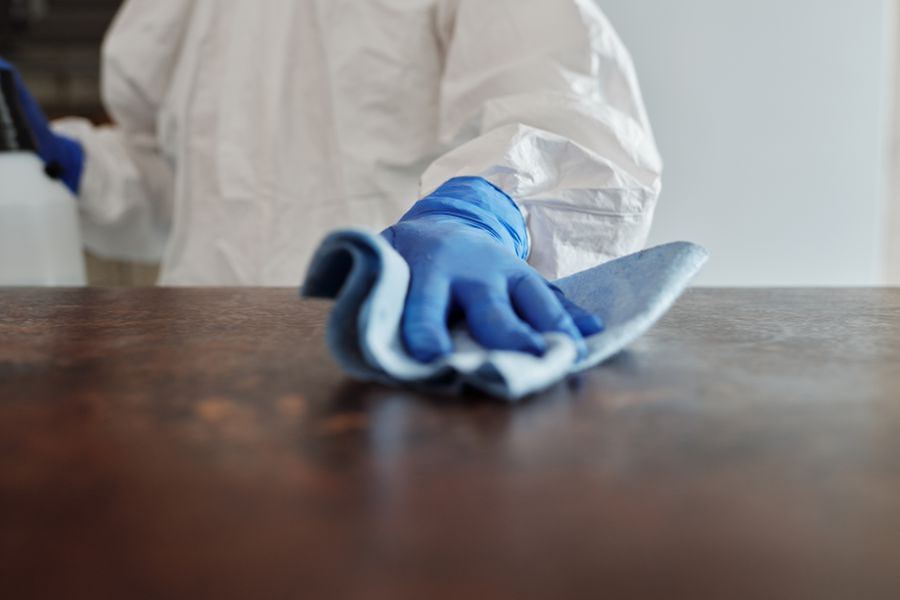 Schreibtisch wird mit Tuch abgewischt